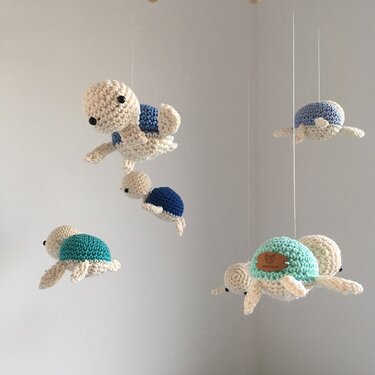 Mehrere gehäkelte Amigurumi‑Schildkröten in Blau‑ und Türkistönen als Mobile