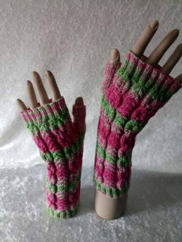 Fingerlose gestrickte Handstulpen in Pink und Grün mit Noppenmuster und Daumenöffnung, auf Modellhänden präsentiert