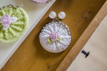 Kompaktes rundes gehäkeltes Münzmäppchen mit Metallklapprahmen und rosa Blüte