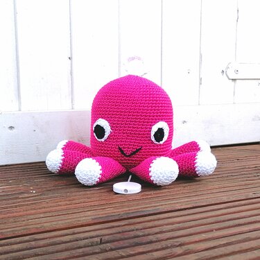 Pinker gehäkelter Oktopus mit weißen Tentakelspitzen und großen Augen