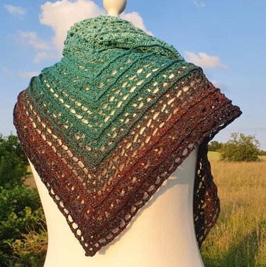 Gehäkeltes Dreieckstuch mit grün-braunem Farbverlauf auf Schaufensterpuppe