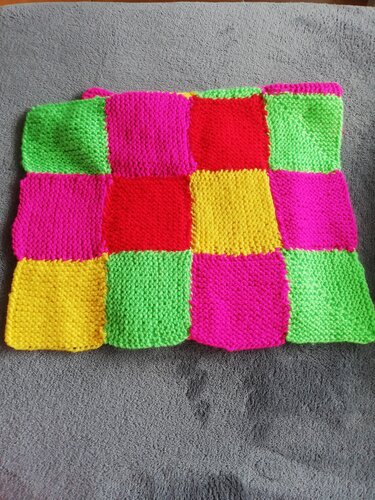 Patchwork-Babydecke aus leuchtenden Quadraten in Pink, Grün, Gelb und Rot