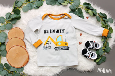 Kinder-Langarmshirt mit gelbem Bagger, der die Zahl 2 in der Schaufel hält, ergänzt durch den Schriftzug 'ICH BIN JETZT'.