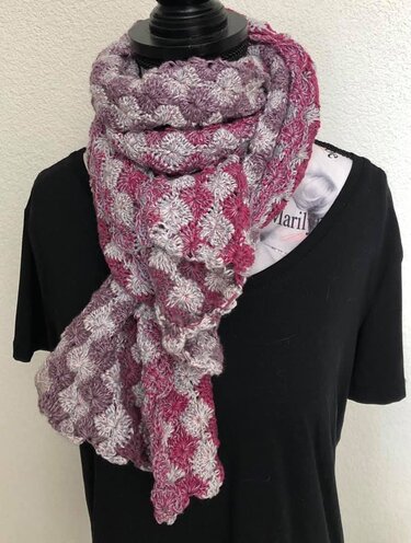 Gehäkelter Schal in Rosé und Grau mit Muschelmuster, an einer Schaufensterpuppe drapiert