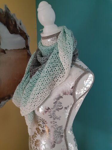 Gehäkelter Schal mit Farbverlauf in Weiß, Mintgrün und Grau auf einer dekorativen Schneiderpuppe