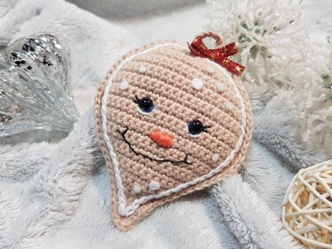 Verspielter gehäkelter Lebkuchen-Anhänger mit Lächeln und roter Schleife