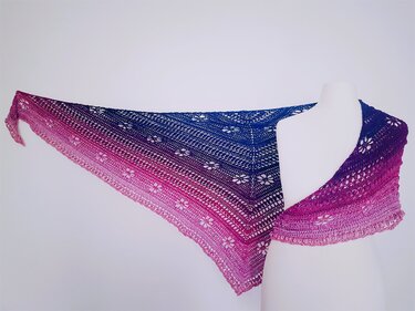 Gehäkeltes Dreieckstuch mit Blau–Pink Farbverlauf und Spitzenblüten auf weißer Schaufensterpuppe