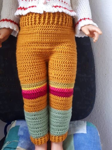 Gehäkelte Kinderhose in Senfgelb mit bunten Streifen und mintgrünen Bündchen
