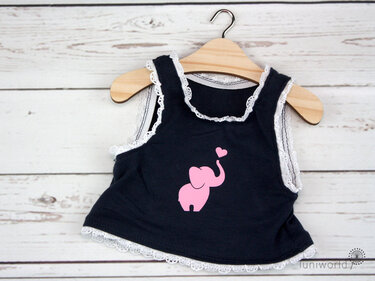 Dunkelblaues Baby-Top mit rosa Elefanten- und Herzmotiv, verziert mit weißer Spitze, auf einem Holzkleiderbügel.