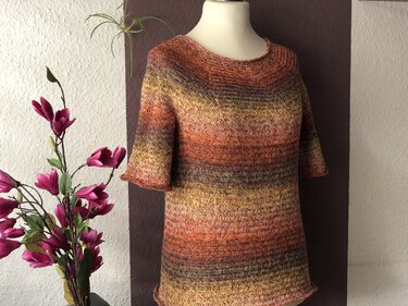 Damen-Strickshirt in warmen Herbstfarben mit Chevronmuster auf Schneiderpuppe