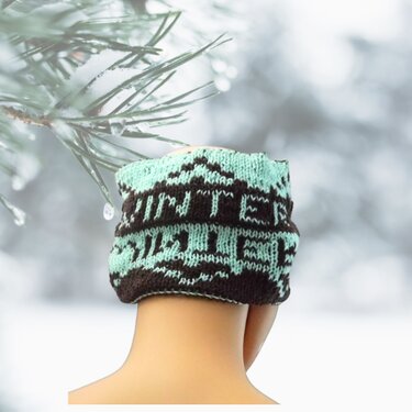Gestrickter Loop in Mint und Dunkelbraun mit 'WINTER'-Jacquard, getragen als Kopfbedeckung