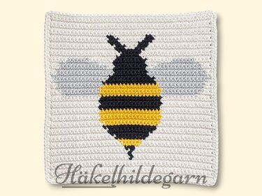 Gehäkeltes Quadrat mit pixelartiger Biene in gelben und schwarzen Streifen und grauen Flügeln auf hellem Hintergrund
