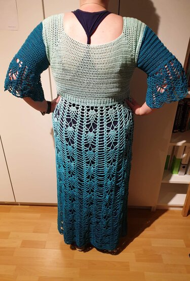 Rückansicht eines gehäkelten Tops und eines langen Rocks in Mint- und Türkistönen.