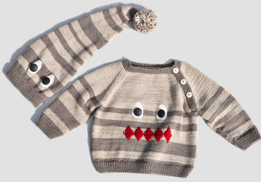 Gestreifter Baby-Strickpullover mit Knöpfen und passende Zipfelmütze mit Pompon, beides mit Monstergesicht-Applikation.