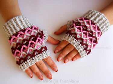 Fingerlose gehäkelte Handschuhe in Grau, Rosa und Weinrot mit Gittermuster, getragen an beiden Händen.