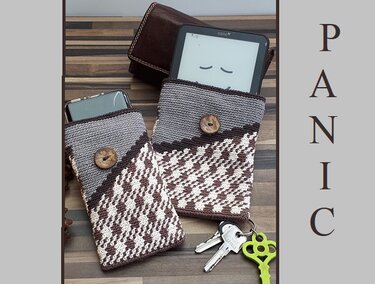 Zwei gehäkelte Taschenhüllen in Braun, Grau und Creme mit Holzknöpfen, eine mit E‑Reader, eine mit Smartphone auf Holztisch