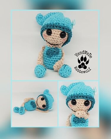 Sitzende gehäkelte Amigurumi-Puppe in Blau und Beige mit Mütze und großäugigem Gesicht auf hellem Hintergrund