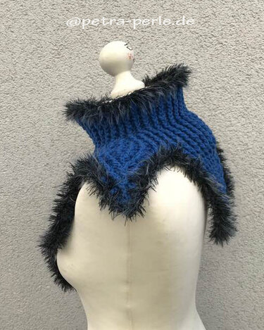 Blauer gehäkelter Kragenschal mit dunklem, flauschigem Rand auf weißer Schaufensterpuppe