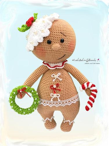 Gehäkelte Amigurumi-Lebkuchenpuppe mit weißem Zuckerguss, grünem Kranz und rot-weißem Zuckerstab