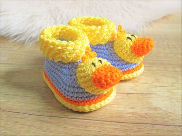 Gehäkelte Babyschuhe mit gelber Enten-Applikation und hellblauem Schaft
