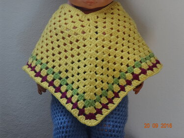 Gelber gehäkelter Poncho im Granny
Square
Muster mit grünen und violetten Details.