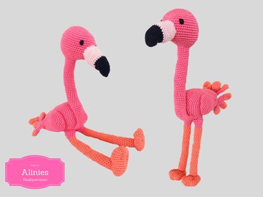 Two crocheted amigurumi flamingos, one seated and one standing, pink bodies with coral-orange legs and black-tipped beaks.