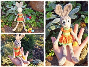 Gehäkeltes Amigurumi-Häschen mit orange-grünem Kleid und bunten Ostereiern, in der Hand gehalten