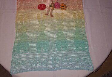 Gehäkelter Tischläufer in Pastellfarben mit Hasenmuster, gehäkelten Eiern und Hasenfigur