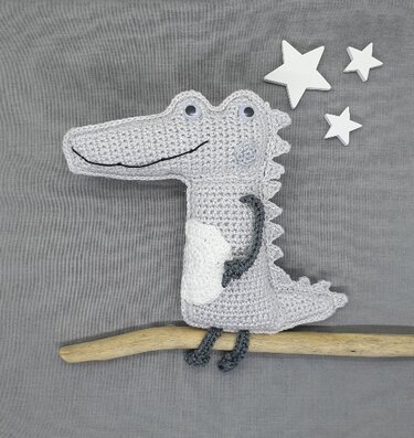 Einfaches gehäkeltes Amigurumi-Krokodil in Grau mit weißem Bauch und kleinen Rückenstacheln