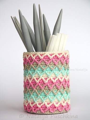 Gehäkelter Aufbewahrungskorb in Pastellfarben mit Stricknadeln
