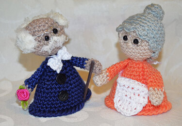 Gehäkelte Eierwärmer Großeltern-Paar, Mann mit blauem Mantel und Rose, Frau mit orangefarbener Schürze und Mütze