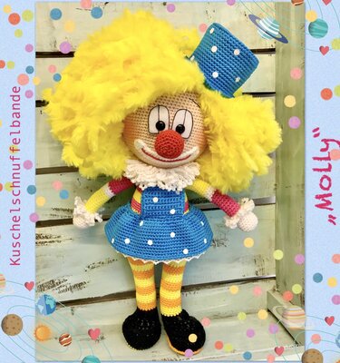 Gehäkelte Amigurumi-Clownpuppe mit flauschiger gelber Haarpracht, roter Nase, blauem Pünktchen‑Latzkleid und gestreiften Beinen