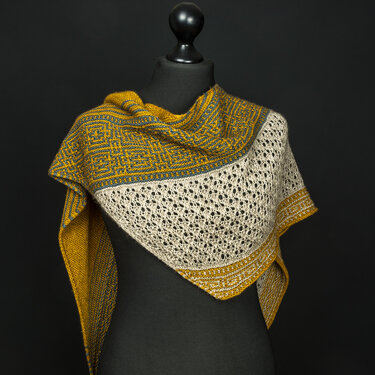Triangular knitted shawl in mustard yellow and cream with a lace center panel displayed on a black dress form