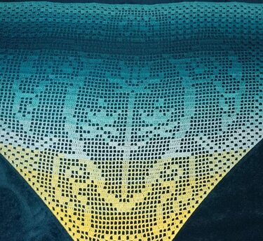 Gehäkeltes Dreieckstuch mit Farbverlauf von Dunkelblau über Türkis zu Gelb und Filethäkelmuster.