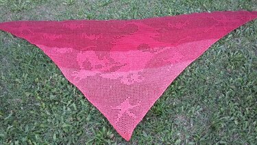 Dreieckiges gehäkeltes Tuch in Rot-Pink-Ombré mit Totenkopfmuster auf Gras