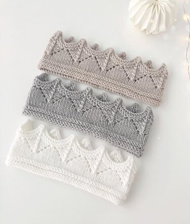 Drei gestrickte Stirnbänder mit Kronenmuster in Beige, Grau und Weiß auf hellem Hintergrund