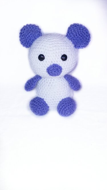 Weißer Amigurumi-Teddybär mit lila Ohren, Schnauze, Armen und Füßen