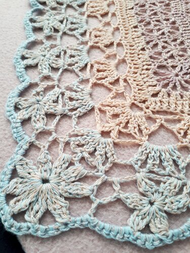 Detailaufnahme Häkelmuster mit Blütenmotiven und Muschelkante