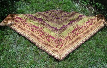 Dreieckstuch mit Häuser- und Streifenmustern in Gelb, Orange und Bordeaux auf grünem Rasen