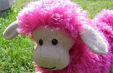Gestricktes Schaf-Kissen mit beigem Kopf und pinkem Flauschfell
