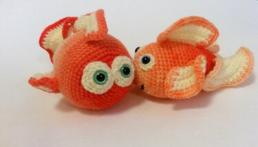 Zwei gehäkelte orange-weiße Goldfische mit großen Augen und sichtbaren Maschen