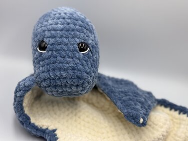 Nahaufnahme eines gehäkelten blau‑creme Schmusetuchs mit Tierkopf