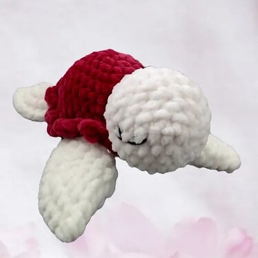 Gehäkelte Amigurumi-Schildkröte mit rotem Panzer und weißen Flossen