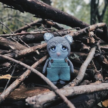 Nahaufnahme einer gehäkelten Katzen-Amigurumi mit Knopfträgern und gestickten Augen