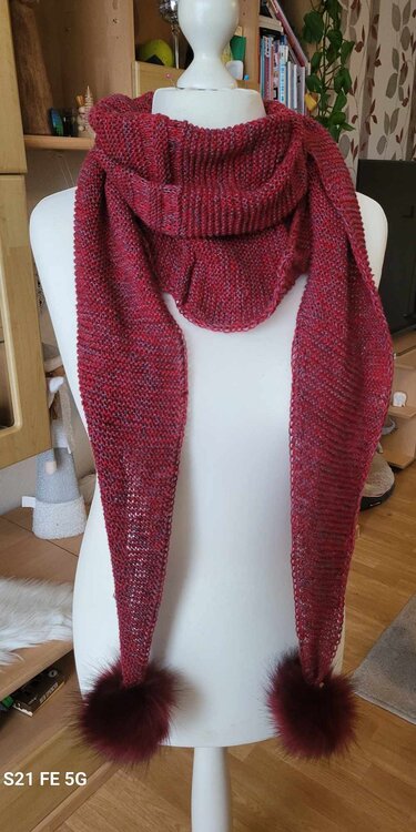 Meliertes, rotes Dreieckstuch mit flauschigen Bommeln an den Spitzen, drapiert an einer weißen Schneiderbüste.