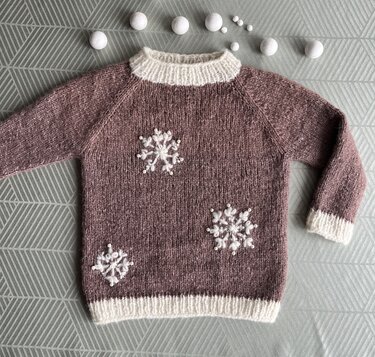 Gestrickter Kinderpullover Braun-Lila mit cremefarbenen Bündchen und Schneeflocken-Applikationen