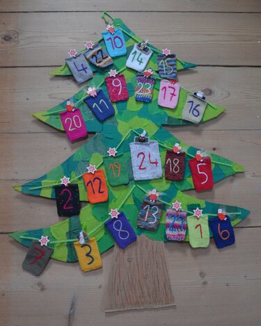 Gestrickter Adventskalender in Tannenbaumform mit 24 nummerierten Säckchen