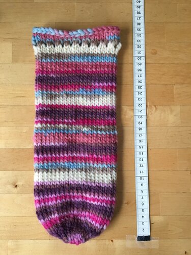 Mehrfarbige Strickprobe mit Rippenmuster und Maßband zur Längenmessung