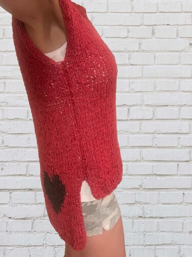 Seitliche Ansicht eines roten grob gestrickten Damen-Tops mit V-Ausschnitt, seitlichem Schlitz und dunklem Herzmotiv