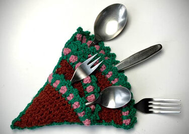 Dreieckiges gehäkeltes Besteck-Utensilo in Grün, Braun und Rosa mit Besteck